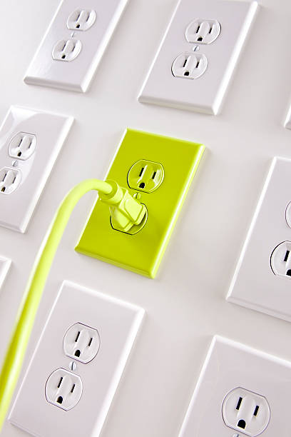 istock Wall  white electrical plugs with one green cord and outlet 157480340