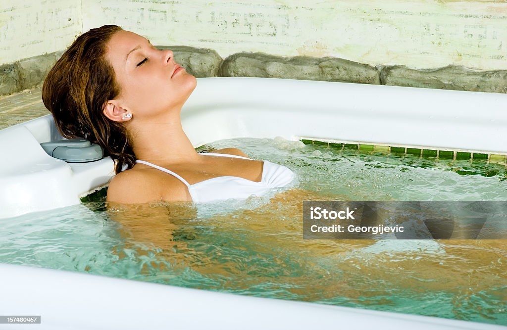 Donna rilassante nella jacuzzi - Foto stock royalty-free di Acqua