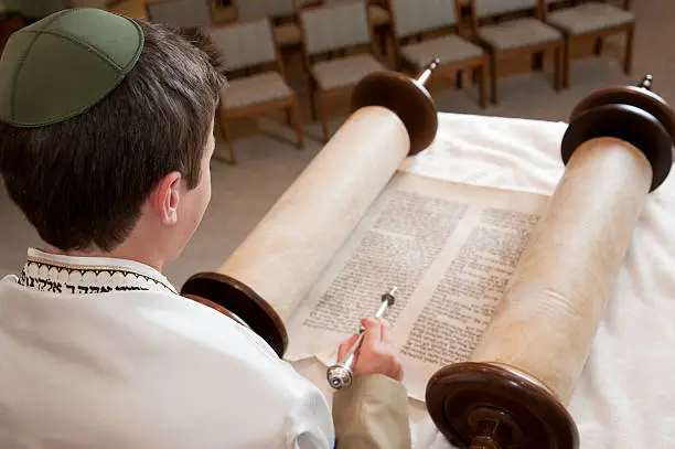 A young man reads the Torah.