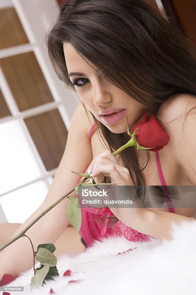 Superbe femme en Lingerie Sexy Allongé sur le lit en tenant Rose - Photo de Lingerie féminine libre de droits