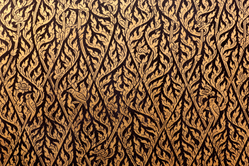 Detail of a Thai decorative gilt lacquer motif on an antique cabinet. 