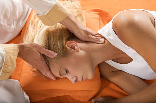 A woman is laying down while hands massage her head Zen Shiatsu therapist shiatsu stock pictures, royalty-free photos & images