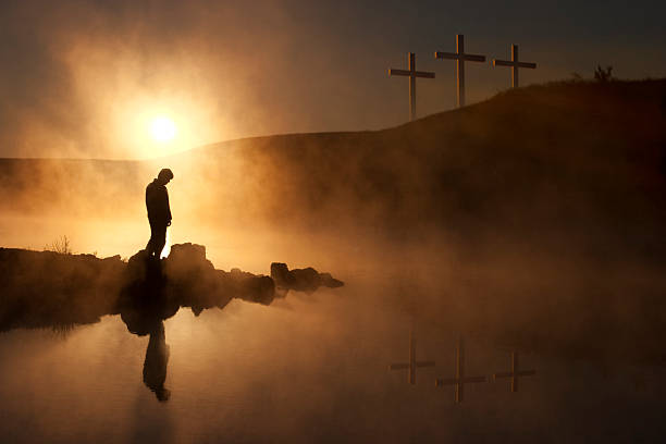 de las tres cruces en pascua puesta de sol sobre el lago con silhouetted persona - easter praying cross cross shape fotografías e imágenes de stock