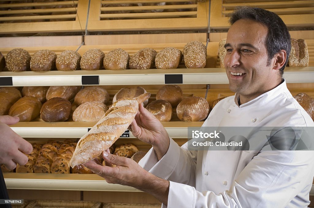 Baker con baguette - Foto de stock de Pan - Comida básica libre de derechos