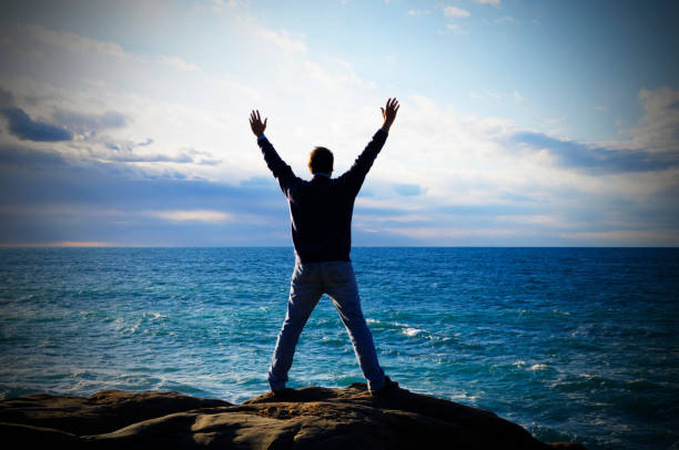 istock Man by Sea Praying to the Sky 157481324