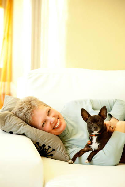 istock Senior Woman Lying on a sofa with Her Dog 157481387