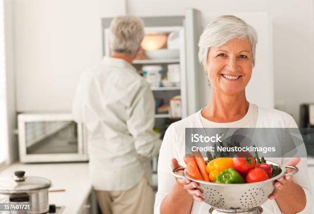 Happy Senior Woman Holding A Bowl Full Of Vegetables Stock Photo - Download Image Now