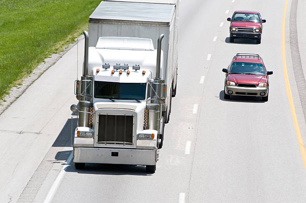 samochody przejazd duże ciężarówki na autostradzie międzystanowej - semi auto zdjęcia i obrazy z banku zdjęć