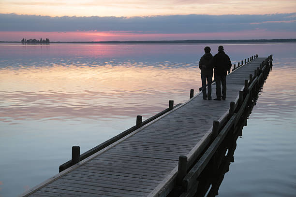 senior couple debout sur lakeside la jetée au coucher du soleil (xxxl - steinhuder meer photos et images de collection