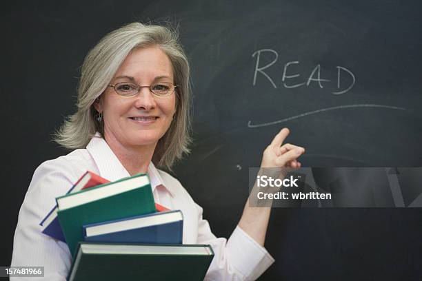 Teacher At The Blackboard Stock Photo - Download Image Now - 40-44 Years, 45-49 Years, 50-54 Years