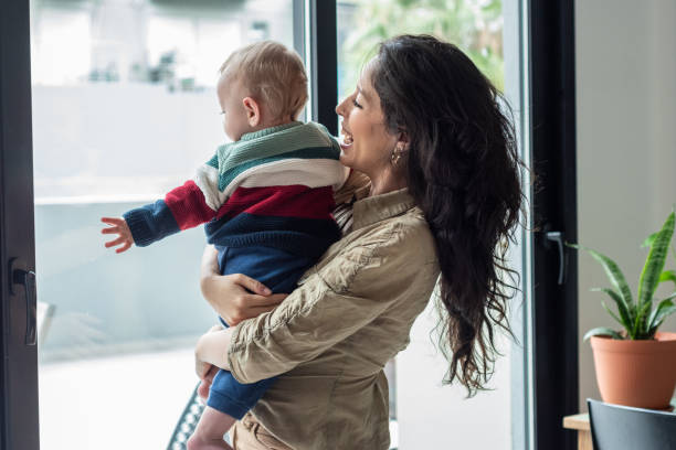 istock Young mom holding her baby son on lap at home 1574821470
