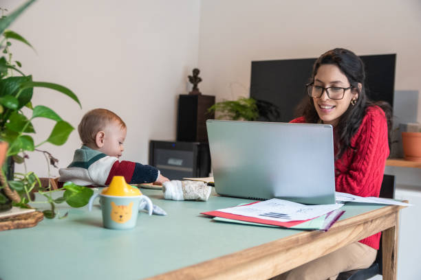 istock Young mom during a video call/web conference on home office while her baby boy eat at home 1574822125