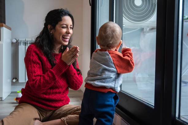 istock Young mother playing clapping with her baby son at home 1574823131