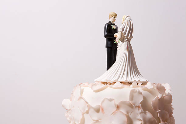 Wedding cake and bride and groom cake topper Happy couple figurine on the top of the Wedding Cake. wedding cake stock pictures, royalty-free photos & images