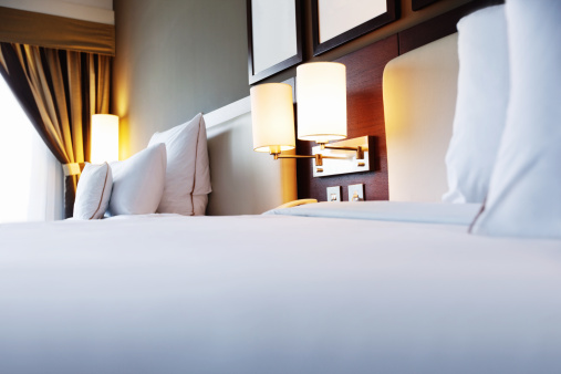 two white pillows on bed with lamp light at night in bedroom