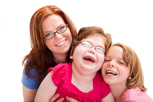 Happy Mother and Two Laughing Daughters Photograph portrait of a beautiful young mother with her two daughters, one with Cerebral Palsy; copy space  cheek to cheek photos stock pictures, royalty-free photos & images