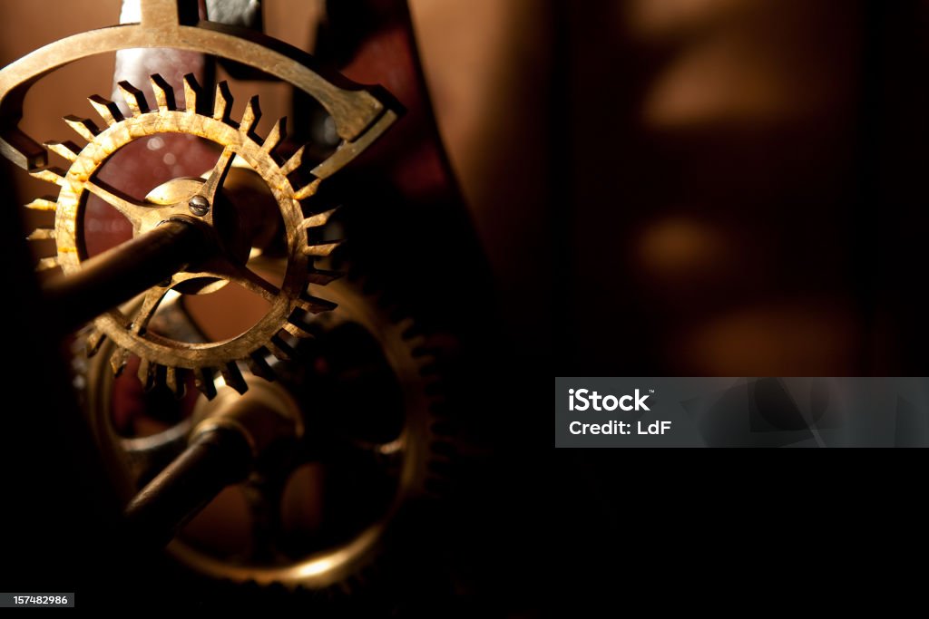 Old Clock gear closeup Low key image of an ancient clock box. Focus on the gear. Copyspace in the dark area. Machinery Stock Photo