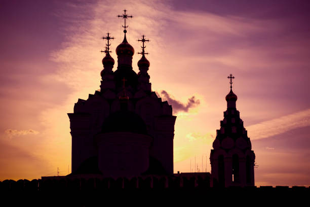 One of the famous church and bell tower at Yoshkar-Ola city, Russia, under a dramatic sky, opposite the sun.