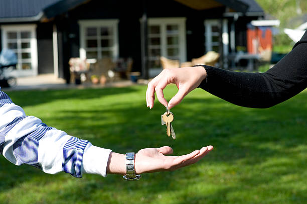 istock Real estate agent hands over keys over to new owner 157483216