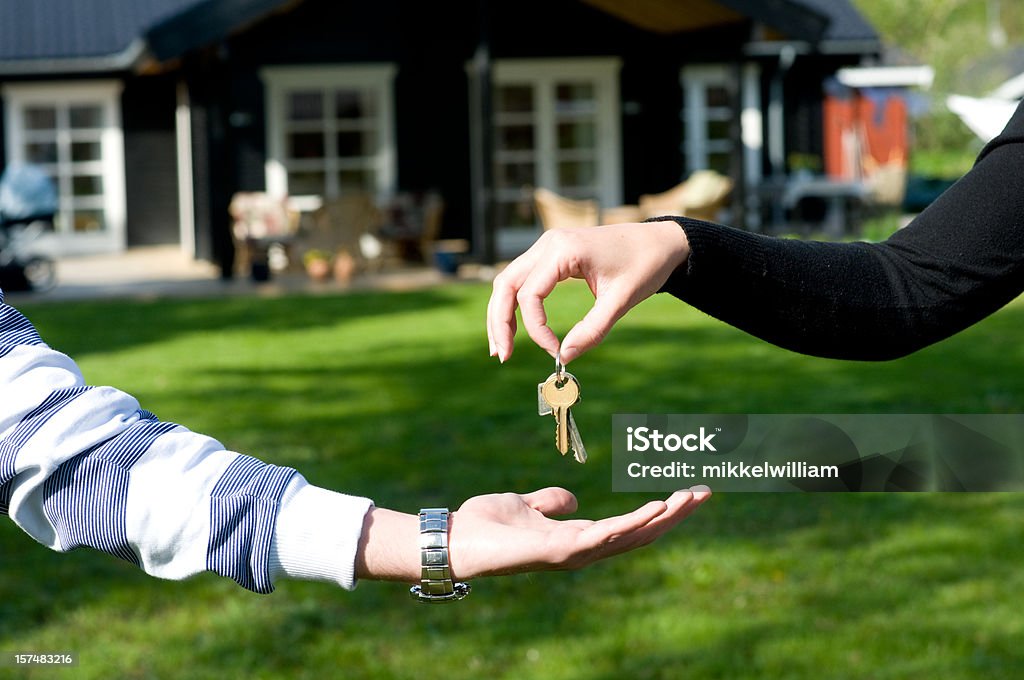 Real estate agent hands over keys over to new owner  Giving Stock Photo