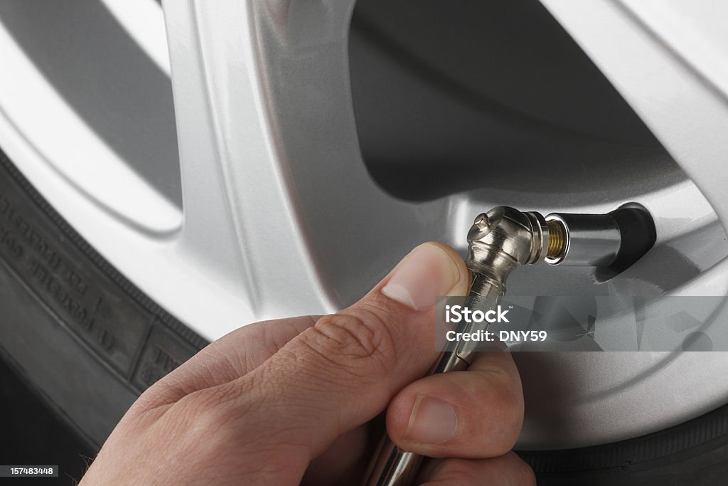 Checking Air Pressure In An Automobile Tire Close up of someone checking the air pressure in a car tire. Tire - Vehicle Part Stock Photo