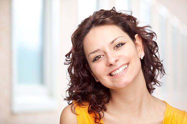 istock Young brunette woman dressed in orange and smiling 157483648