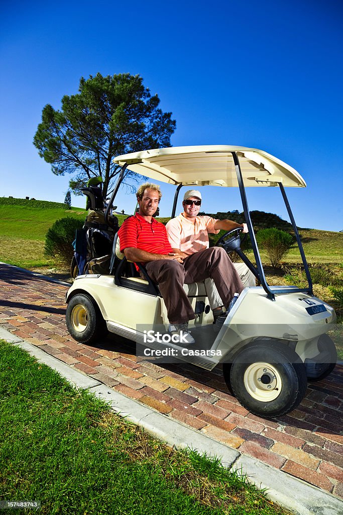 Golfers chilling out in the golf cart Two friends on golf course Golf Cart Stock Photo