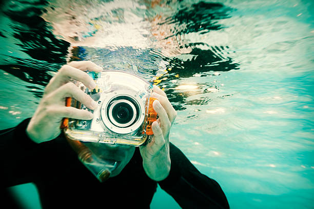 Snorkeling Photographer, Holga Style A snorkeler takes a photo with an underwater camera. Taken in the Maldives. Cross-processed Holga treatment. See also: cross processed stock pictures, royalty-free photos & images