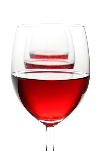 Three glasses of red wine isolated on white, side view, arranged in a row. Focus on foreground, studio shot.