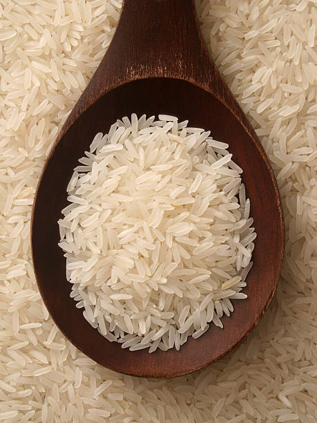Jasmine rice Top view of wooden spoon full of jasmine rice variety jasmine rice stock pictures, royalty-free photos & images