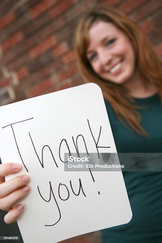 Jolie jeune femme tenant un panneau Merci - Photo de Thank You - Petite phrase libre de droits