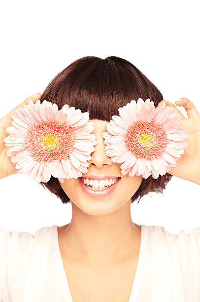 istock Playful Brunette Covering Her Eyes with Pink Flowers 157484523