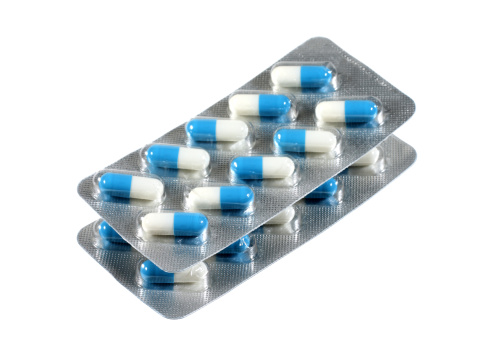 A pile of blue and white pills in blister on white background.