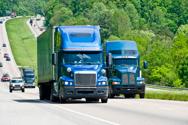istock Two Blue Semi Trucks Climb Hill On Interstate Highway 157484888
