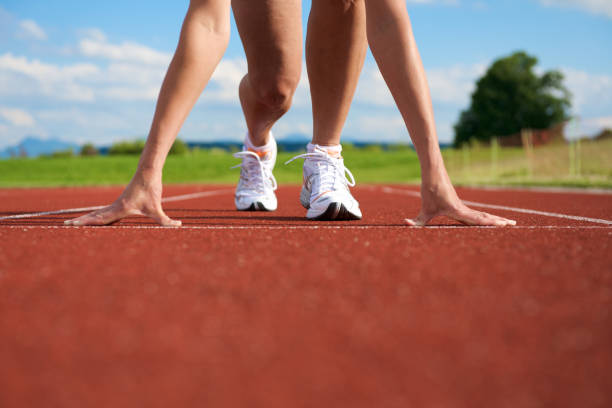 A woman getting ready to sprint on the track and field