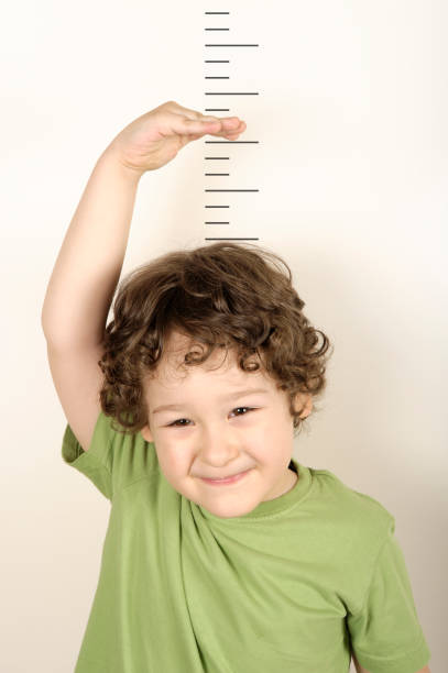 istock A growing child measuring his height 157485225