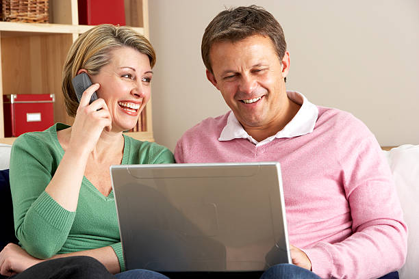 Middle aged couple learning how to use a laptop stock photo