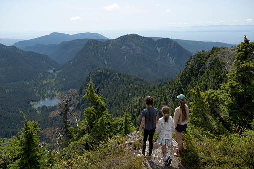 Mother and daughters hiking in the mountains. Nature and active lifestyle themes.