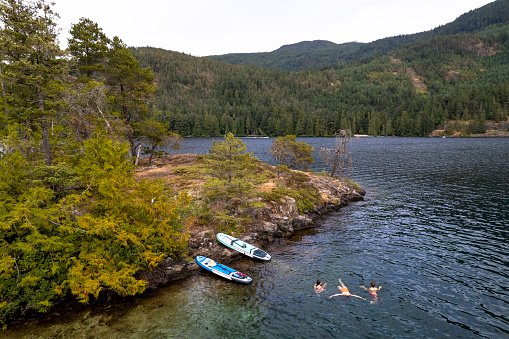 Paddleboarding on a family vacation. Top travel destinations in BC. Ruby Lake, Sunshine Coast.