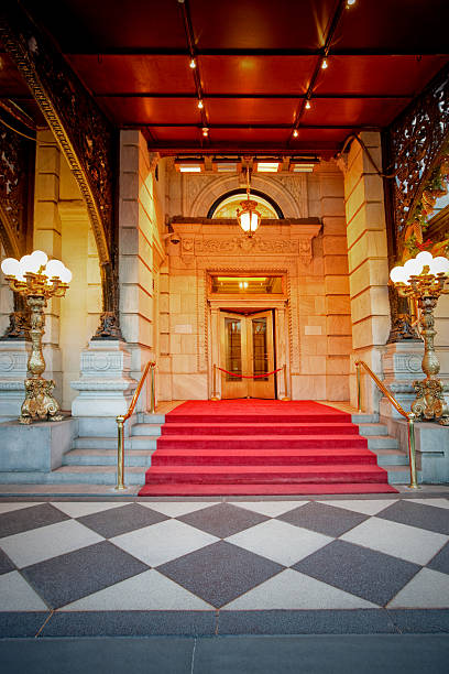 Red Carpet Marble steps covered with red carpet leading to the rope barrier and closed door stairwell chandelier stock pictures, royalty-free photos & images