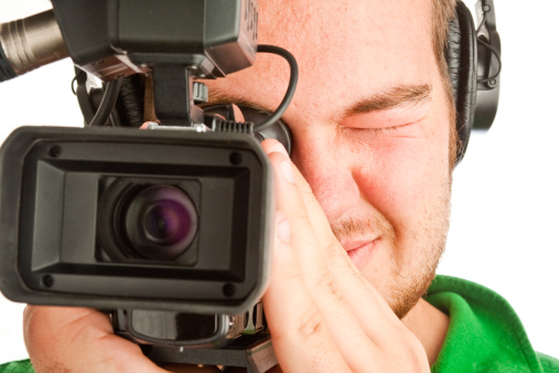 Teenage boy operating a camcorder with intentionally shallow depth of field with focus on lens