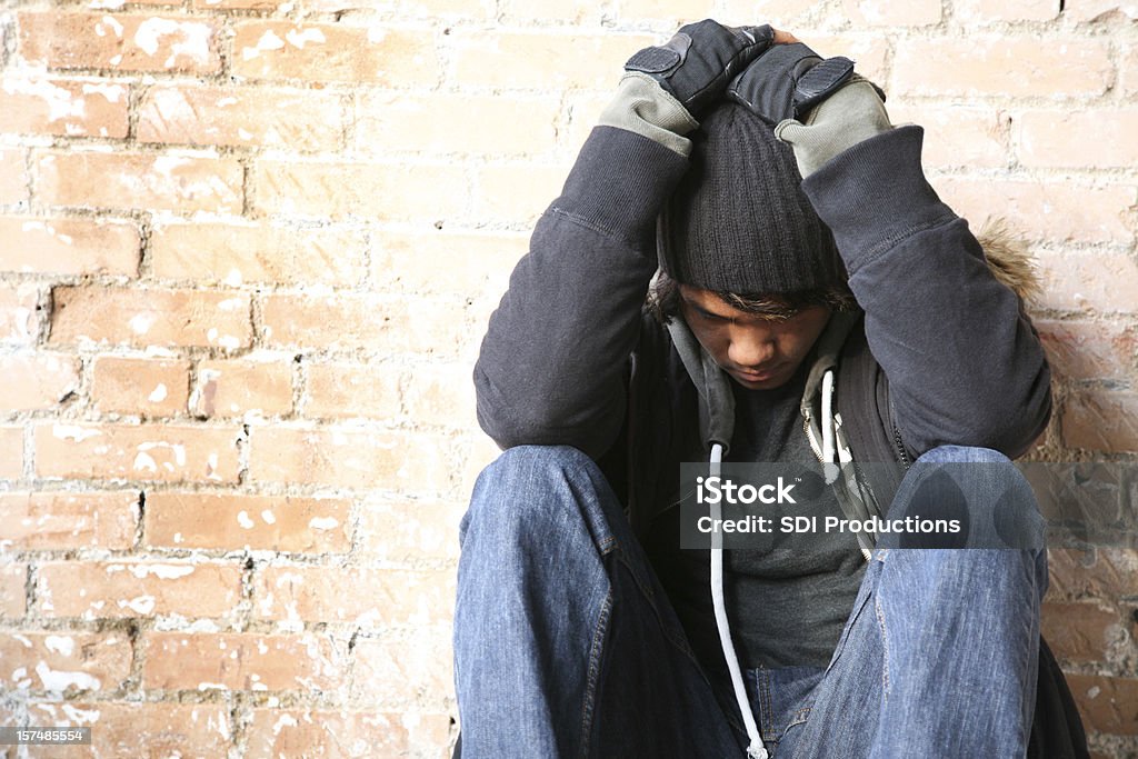 눌린 사람이 앉아 벽돌전 벽 - 로열티 프리 홈리스 스톡 사진