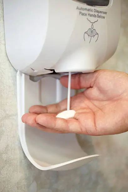 Photo of Sanitizer Dispenser Dispensing Liquid Soap Into a Male Hand