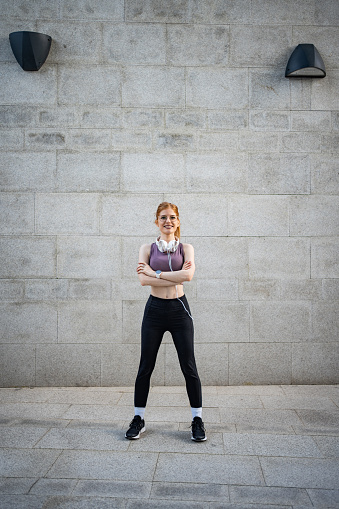 Athletically built young woman posing confidently in her sports gear. Her figure reflects strength and endurance, while at the same time suggesting grace and a willingness to face challenges.