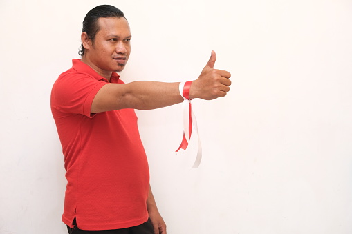 asian man giving thumbs up on the theme of celebrating the independence day of the Republic of Indonesia