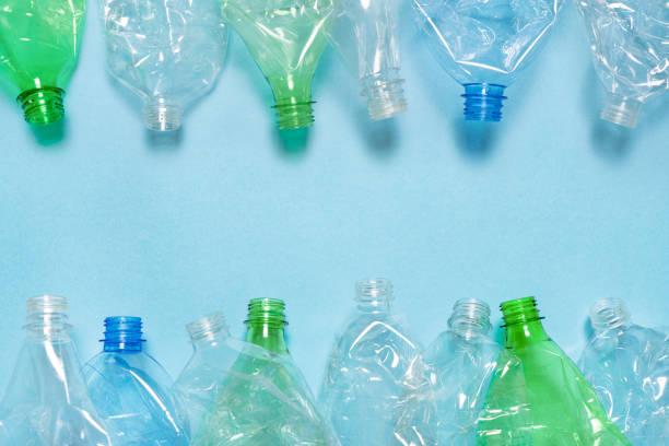 istock Flat crushed bottle crumpled plastic garbage PET recycling background trash. Flat plastic bottle recycling design blue paper. Row empty bottle PET plastic recycling concept. Reuse. Used. Waste sorting 1574921792
