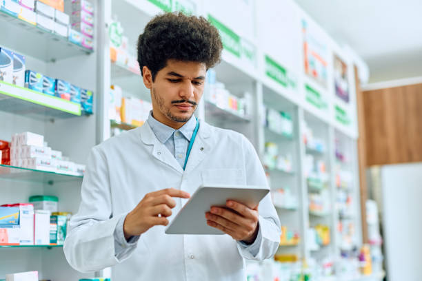 istock Male pharmacist working on digital tablet in a pharmacy. 1574922740