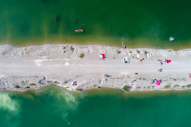 Aerial view of people sunbathing on the beach and swiming in the lake.