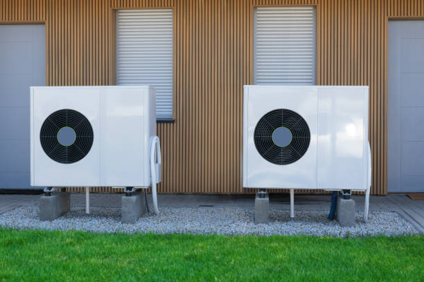 istock Two eco-friendly air-source heat pumps in front of a modern house. 1574983447