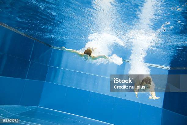 Underwater View Of A Young Couple Jumping Into The Water Stock Photo - Download Image Now